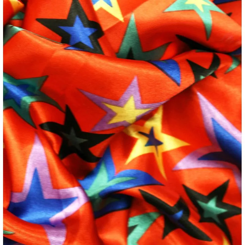 Satin polyester étoiles multicolores sur fond rouge