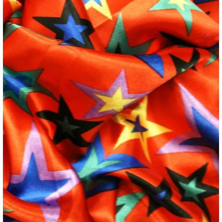 Tissu Satin polyester étoiles multicolores sur fond rouge